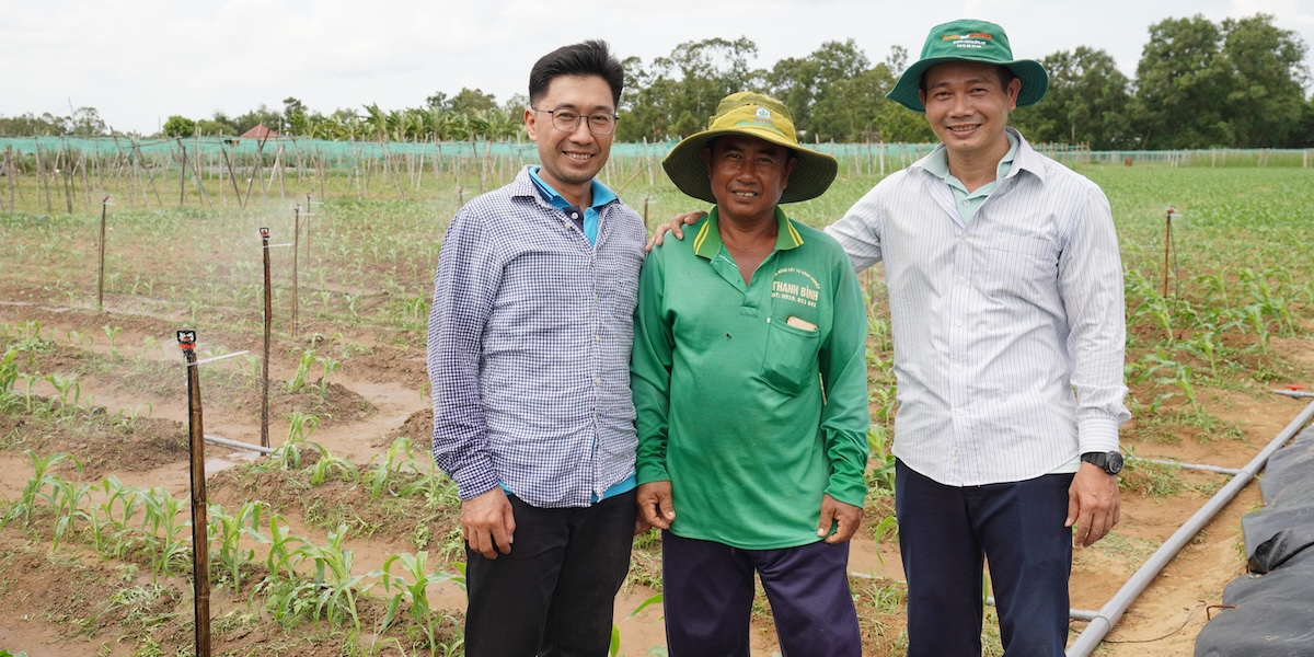 Three men pose next to the farm with the irrigation system in Viet Nam