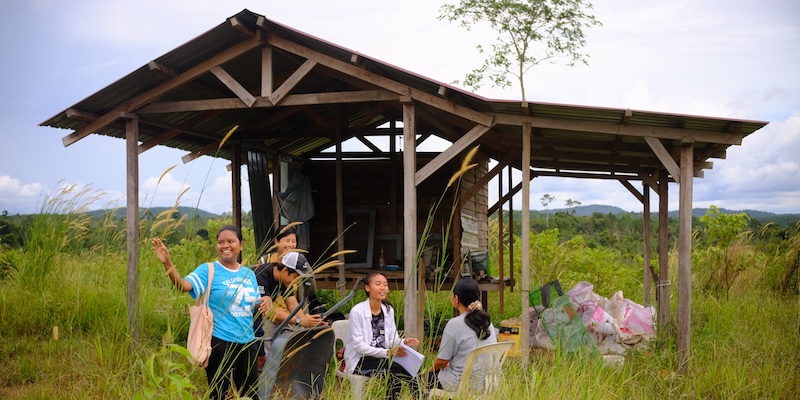 Farmers relax by a rest house in the fields of Malaysia.