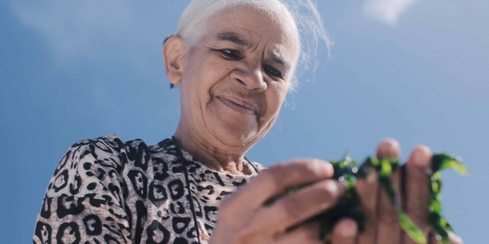 Fisher Hilda April Adams holds algae from the ocean
