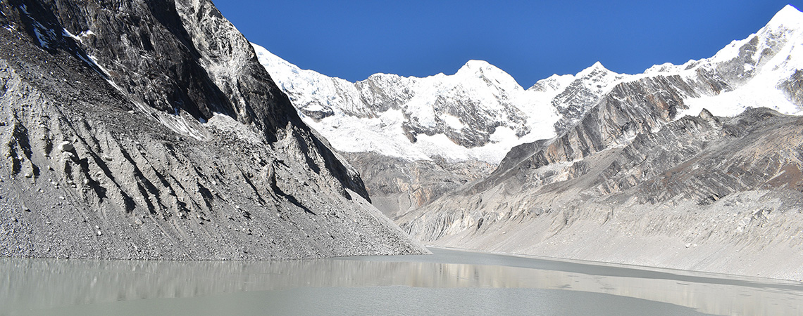 A high-altitude glacial lake surrounded by steep, snow-covered mountains in the Everest region of Nepal.