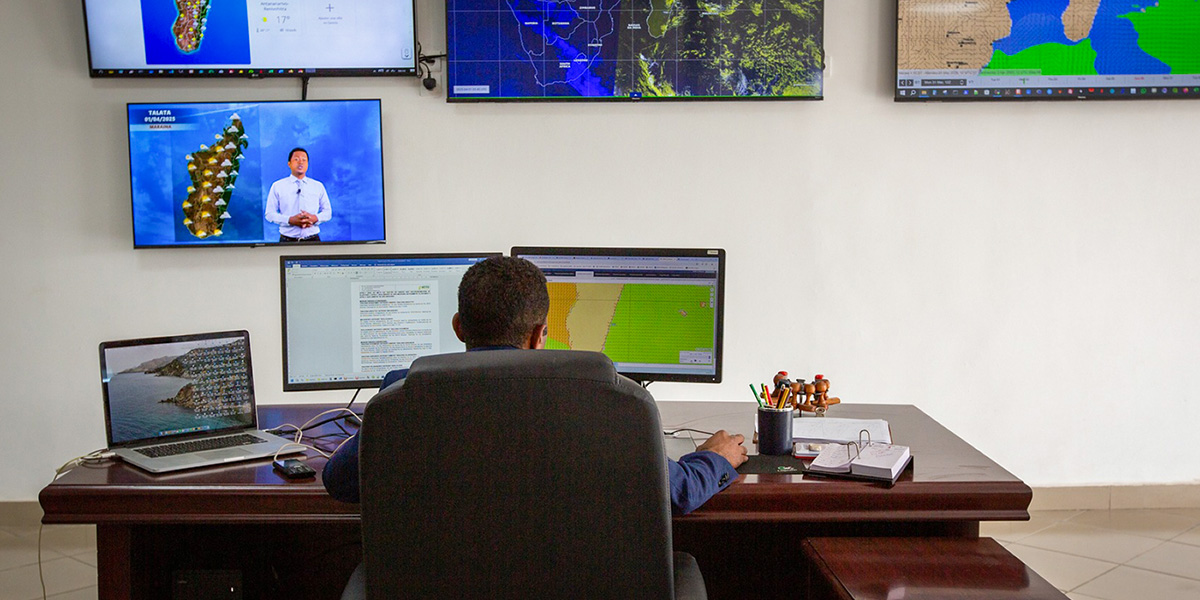 A meteorologist at Météo Madagascar monitors real-time weather and climate data on multiple screens to support early warnings for cyclones and droughts.